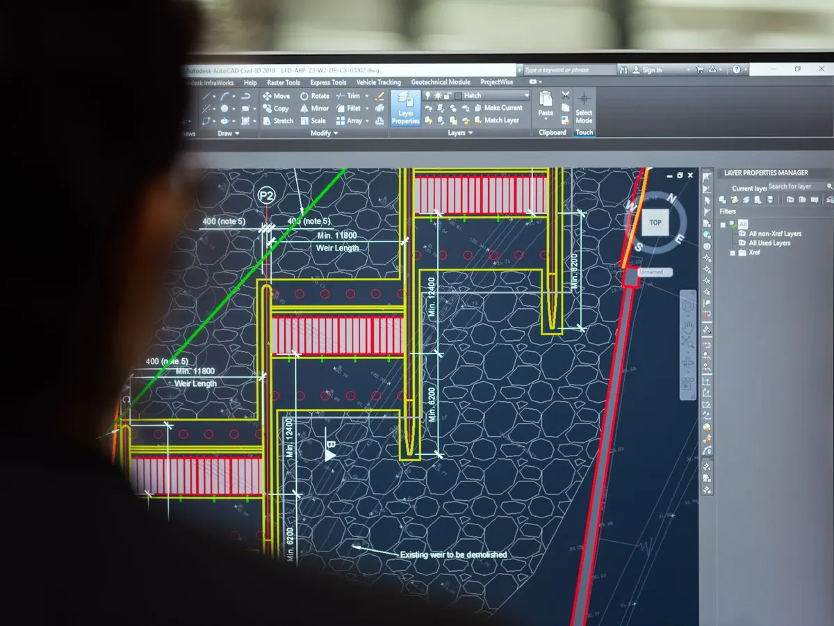 Ingeniero trabajando sobre un plano técnico en la pantalla del ordenador